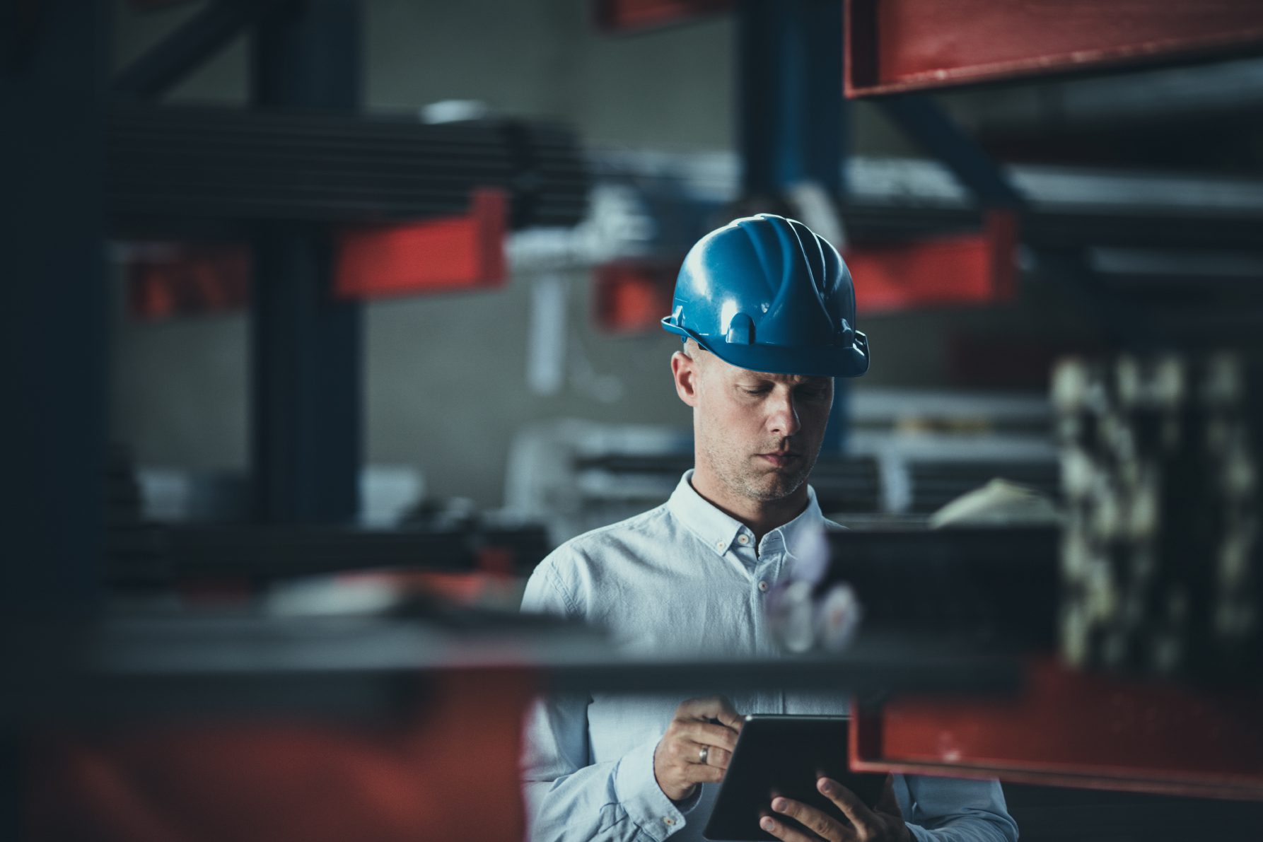 Mid adult foreman working on digital tablet in aluminum mill.